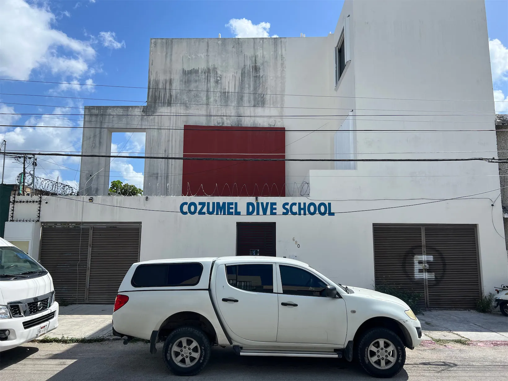 The street-front entrance of Cozumel Dive School, with a pickup truck parked outside